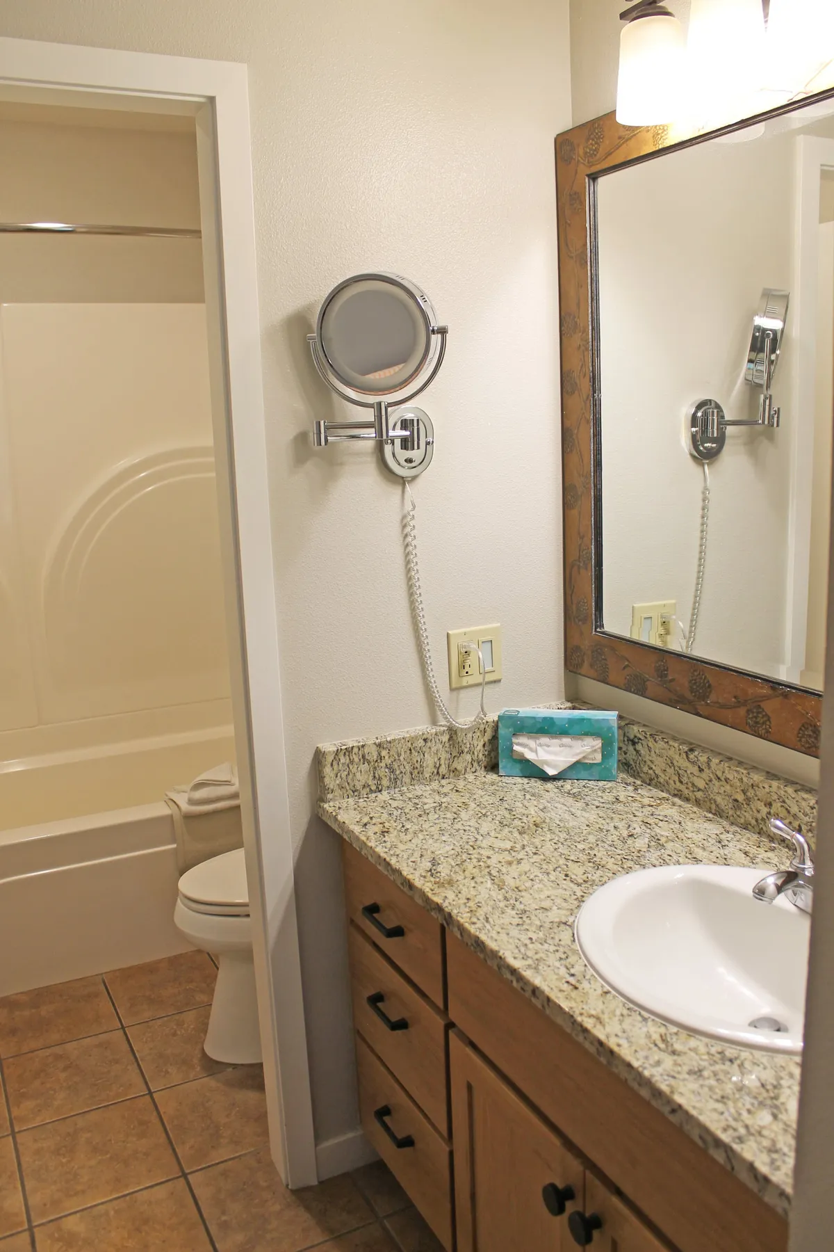This image features a modern bathroom with a granite countertop, large mirror, and glass shower area. The space feels bright and calming, offering a sense of luxury and a spot for refreshing routines.